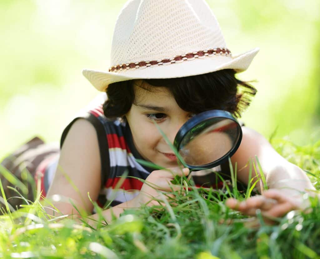 Happy,kid,exploring,nature,with,magnifying,glass